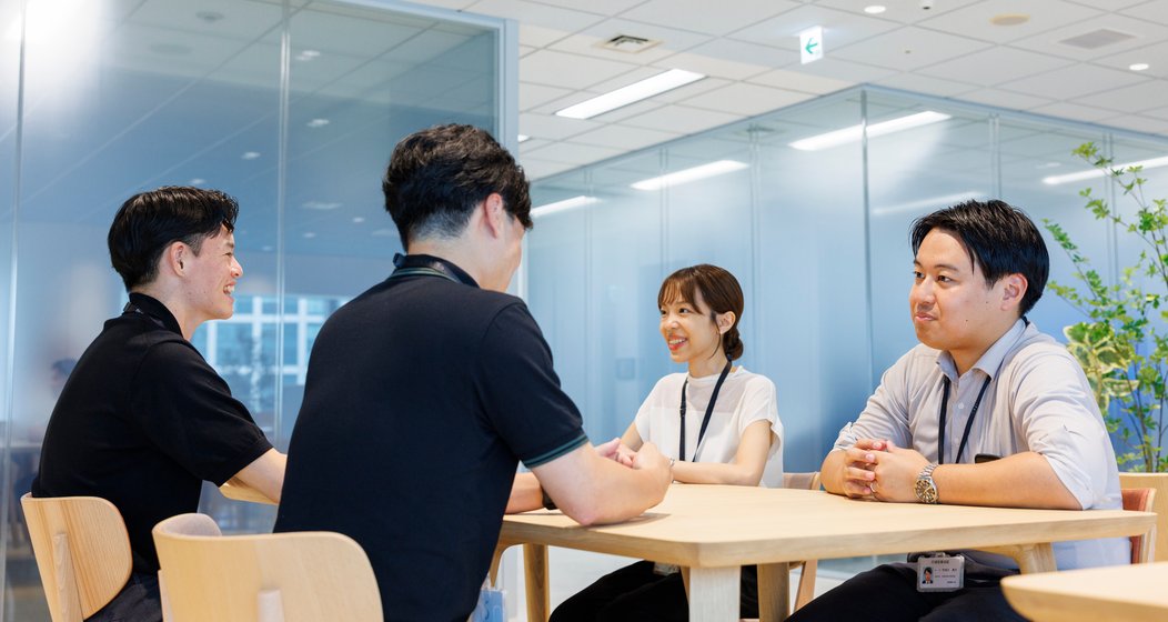 テーブルを囲んで話す社員たち